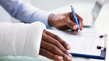 An injured man is filling out a document.